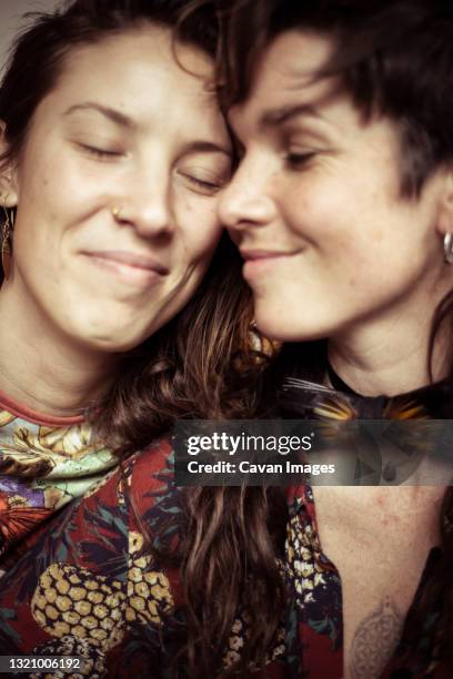 smiling young beautiful women share a loving intimate moment - androgyn stock-fotos und bilder
