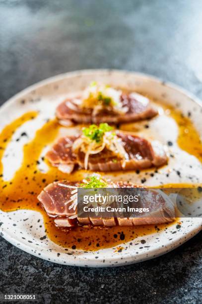 marinated tuna sashimi at sushi bar in northern thailand - fines herbes stock-fotos und bilder