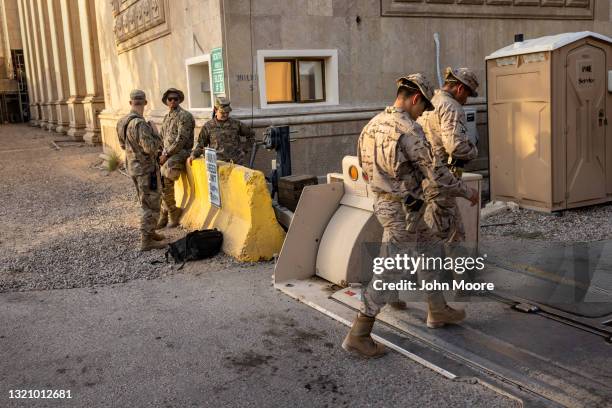 Army soldiers watch as fellow Coalition soldiers pass by near the entrance to the International Zone on May 30, 2021 in Baghdad, Iraq. Coalition...