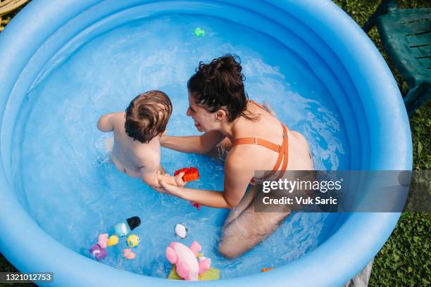 mom and the toddler playing in the inflatable pool - paddling pool stock pictures, royalty-free photos & images