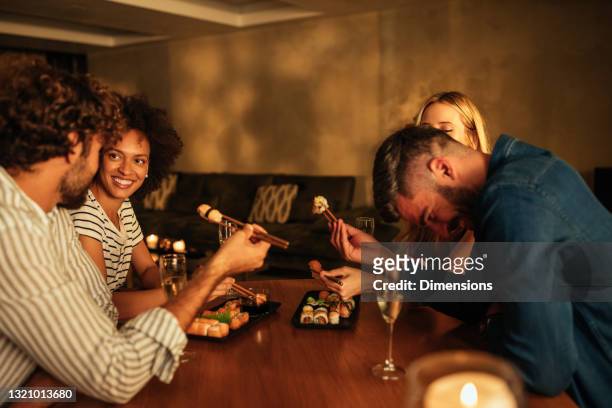 amigos sentados en la mesa del comedor y comiendo sushi - double date fotografías e imágenes de stock