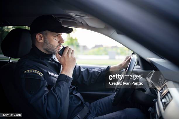 midden oude kaukasische mannelijke politieagent op het werk - auto radio stockfoto's en -beelden