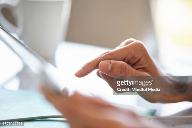 primer plano de la mano de una mujer adulta joven usando el dispositivo de pantalla táctil durante el día - easy solutions fotografías e imágenes de stock
