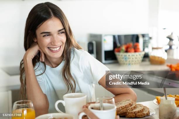 porträt einer lächelnden jungen frau beim frühstück - ehefrau stock-fotos und bilder