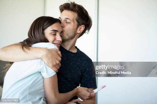 smiling young couple celebrating pregnancy - birth control stockfoto's en -beelden