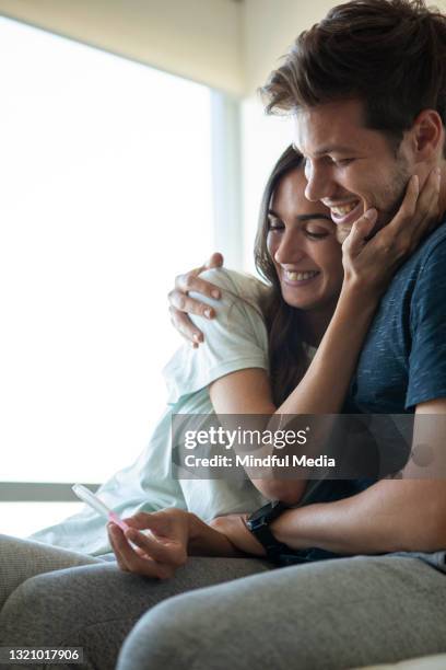 happy couple looking at positive pregnancy test - pelvic exam stock pictures, royalty-free photos & images