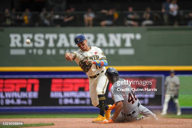 Kolten Wong of the Milwaukee Brewers turns a double play in the sixth inning against Jeimer Candelario of the Detroit Tigers at American Family Field...