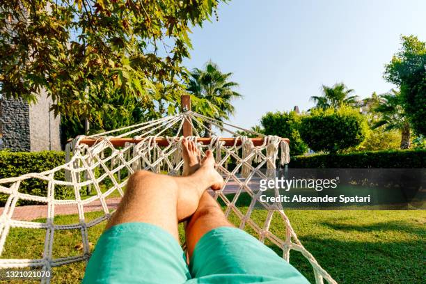 man relaxing in the hammock, pov personal perspective view - hamaca fotografías e imágenes de stock