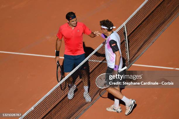 Roger Federer of Switzerland is congratulated on victory by opponent Denis Istomin of Uzbekistan on day two of the 2021 French Open at Roland Garros...