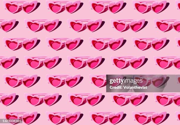 pattern of pink heart-shaped retro sunglasses against pastel pink background - heart sunglasses stock pictures, royalty-free photos & images