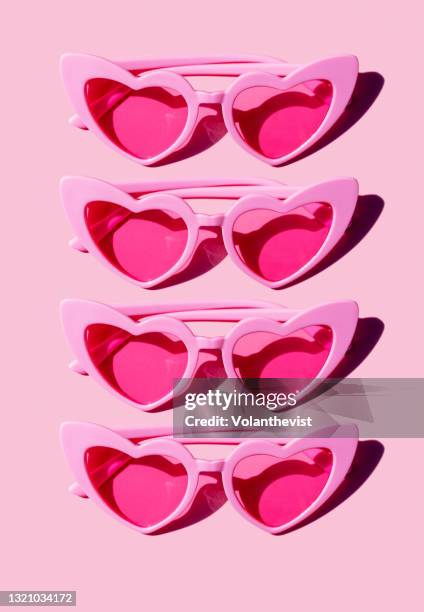 pattern of pink heart-shaped retro sunglasses against pastel pink background - sunglasses pattern stock pictures, royalty-free photos & images