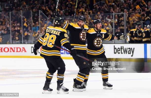 David Pastrnak, Patrice Bergeron and Brad Marchand of the Boston Bruins celebrate Bergeron's goal at 10:34 of the third period against the New York...
