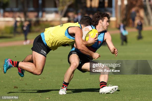 Andrew McGrath gets tackled by Alec Waterman during an Essendon Bombers AFL training session at Hale School on June 01, 2021 in Perth, Australia.