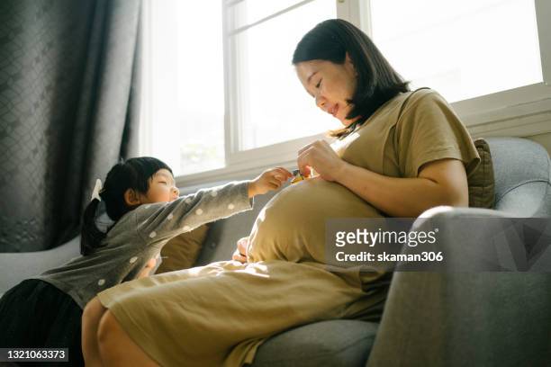 beautiful moment asian mother pregnant second baby and spending time to playing with first daughter at home - asian woman pregnant stock pictures, royalty-free photos & images
