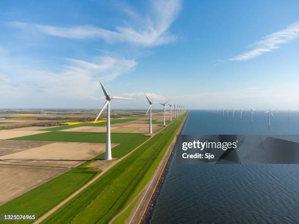 wind turbines on a levee and offshore during springtime seen from above - netherlands water stock pictures, royalty-free photos & images