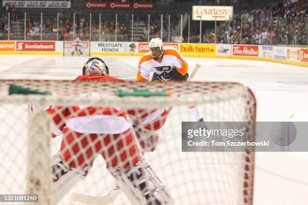 Wayne Simmonds of the Philadelphia Flyers skates in on goal during the shootout as a fan throws a banana onto the ice against the Detroit Red Wings...