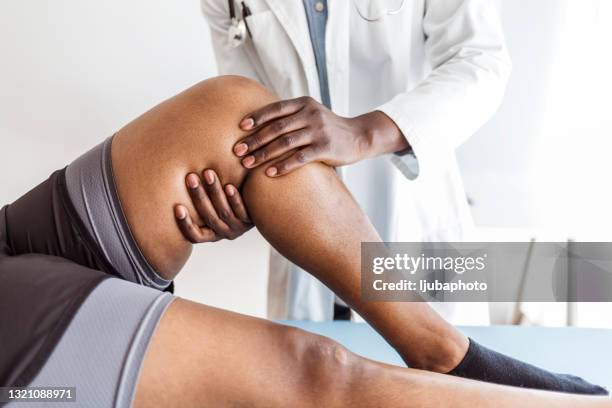 patient in der physiotherapie bei körperlichen übungen mit seinem therapeuten - female knee pain stock-fotos und bilder