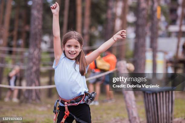 girl spreading her arms when enjoying adrenalin park - ziplining stock pictures, royalty-free photos & images