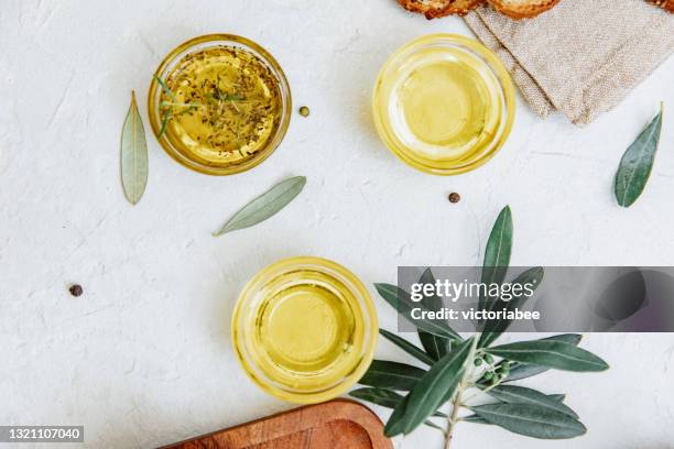 overhead view of three bowls of assorted olive oil on a table - olive oil bowl stock pictures, royalty-free photos & images