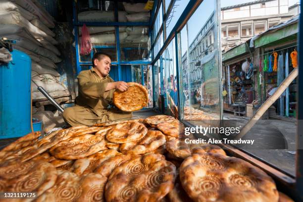 a man makes naan bread in a stall in kabul - afghanistan kabul bread sellers stock pictures, royalty-free photos & images