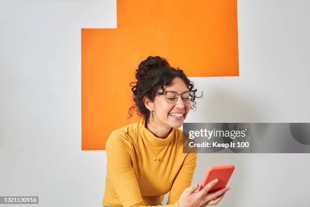 portrait of a woman using her mobile phone - vasthouden stockfoto's en -beelden