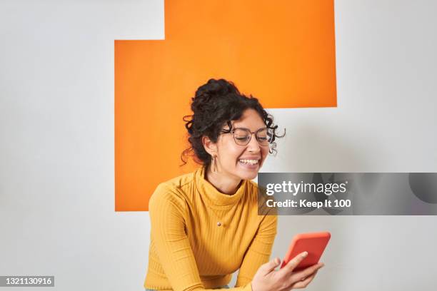 portrait of a woman using her mobile phone - reading glasses imagens e fotografias de stock