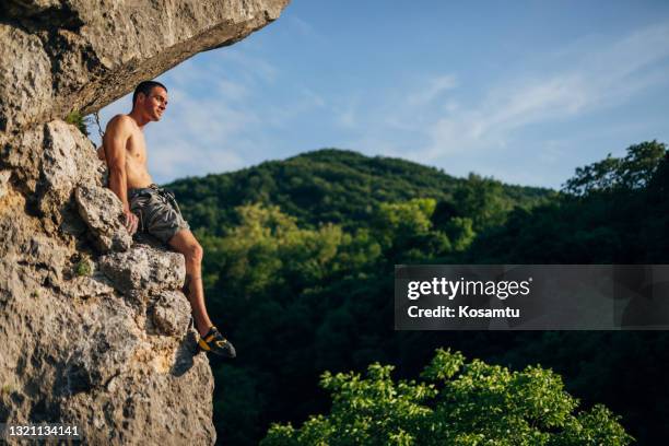 müde freie solo-kletterer, eine pause und genießen sie den blick auf die natur, während sie in der klippe riss ruhen - freiklettern stock-fotos und bilder