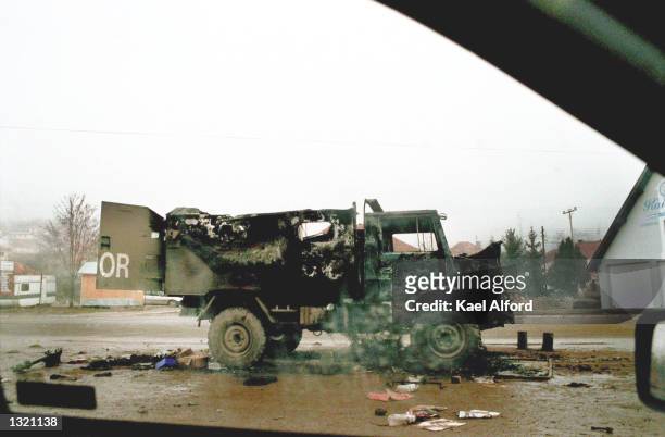 Truck smoulders on the main road December 17, 2000 in Leposavic, Yugoslavia the morning after a mob of Kosovo Serbs attacked a convoy of Belgian...