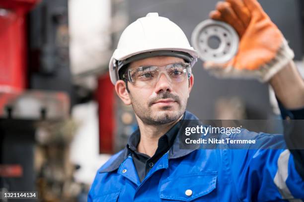quality control assurance in auto part industry. quality control engineer inspecting accuracy of engineering part by visual check compare with quality standard in production line shopfloor. - quality stock-fotos und bilder