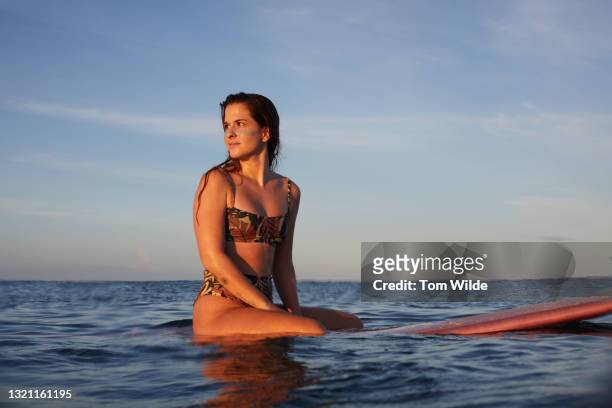 young woman seated on her surfboard - nosara costa rica stock pictures, royalty-free photos & images