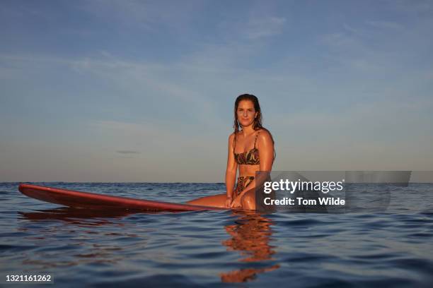 young woman seated on her surfboard - nosara costa rica stock pictures, royalty-free photos & images