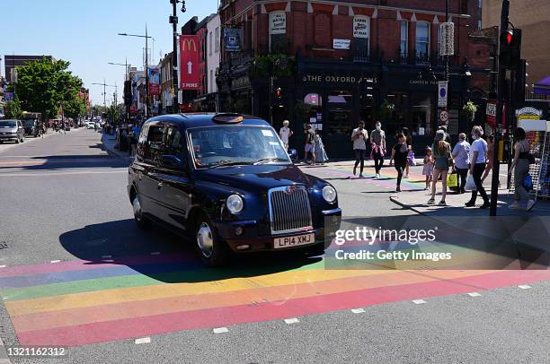 Black cab travels over a rainbow crossing in Camden during UK Pride Month 2021 on June 01, 2021 in London, United Kingdom. June marks Pride month, it...