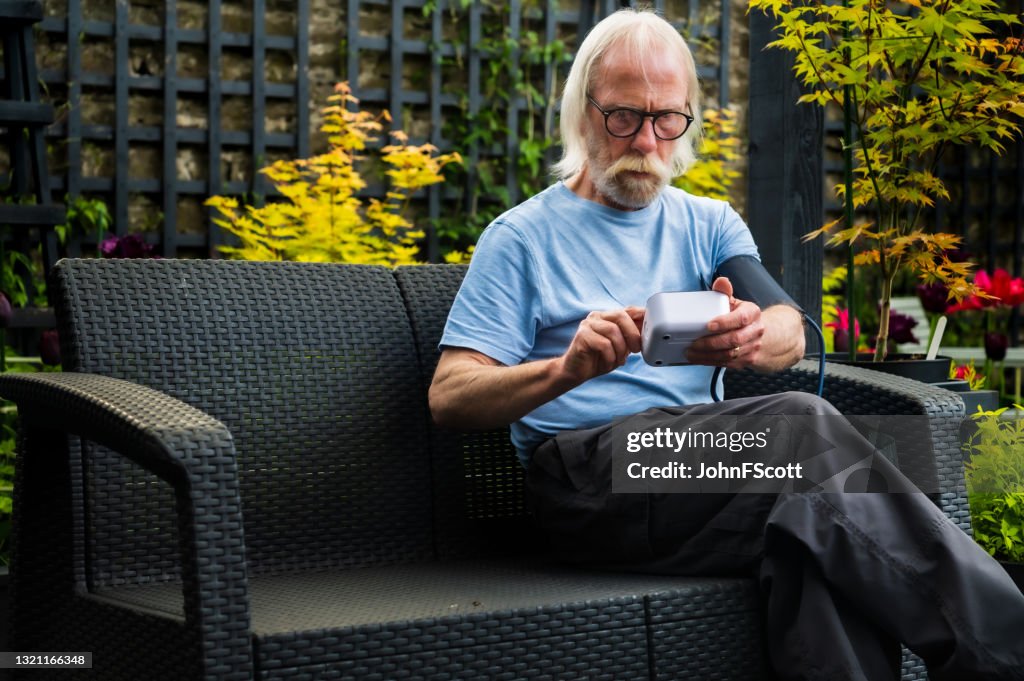 Senior man self checking blood pressure