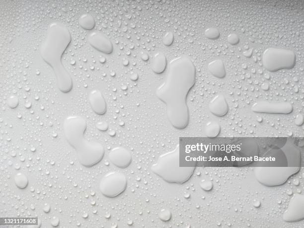 full frame of drops and splashes of water on a white background. - nass stock-fotos und bilder