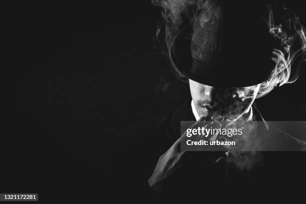 hombre retro con corbata y sombrero fumando - mafia fotografías e imágenes de stock