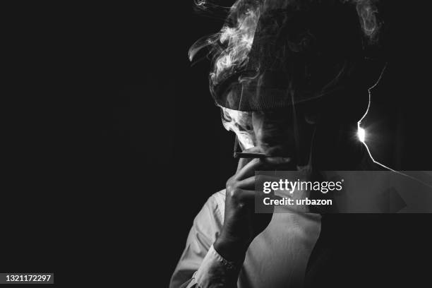 retro man in tie and hat smoking - film noir stock pictures, royalty-free photos & images