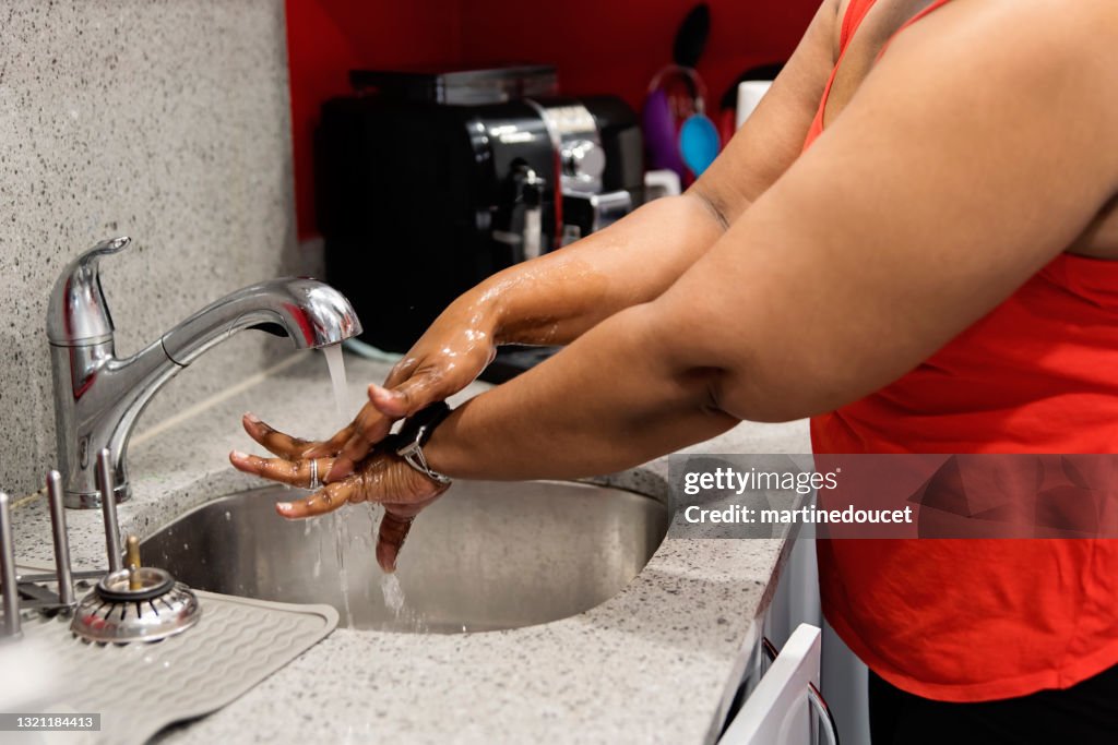 Lichaam positieve vrouw wassen handen in gootsteen.