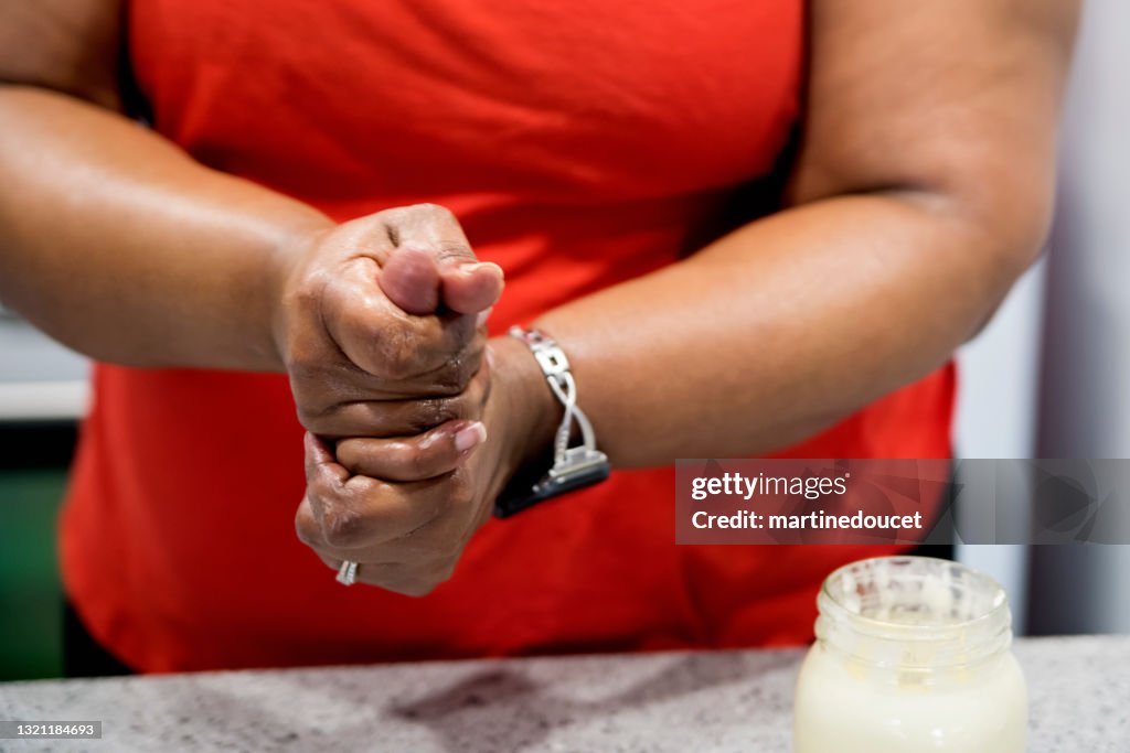 Mujer positiva para el cuerpo frotando en crema de manos casera.