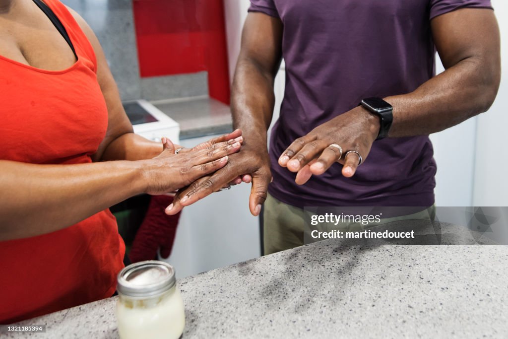 Body positive woman rubbing on homemade hand cream on husband hands.