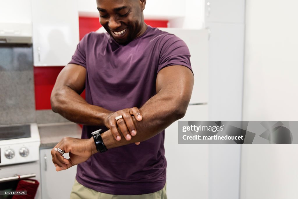 African-American man rubbing on homemade hand cream.