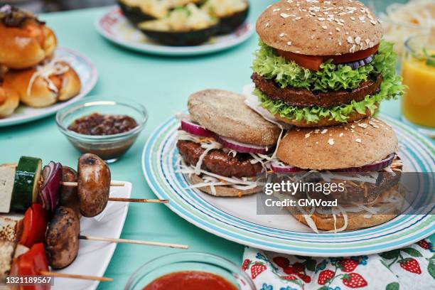 het roosteren van veganistische spiesjes, veganistische hamburgerpasteitjes en groenten op bbq grill - burger grill stockfoto's en -beelden