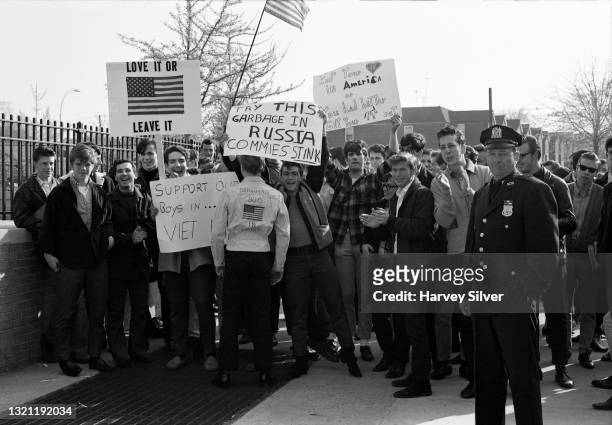 View of a police officer and a group of high school students, several with a signs, as they demonstrate, during a counter protest to an ongoing...