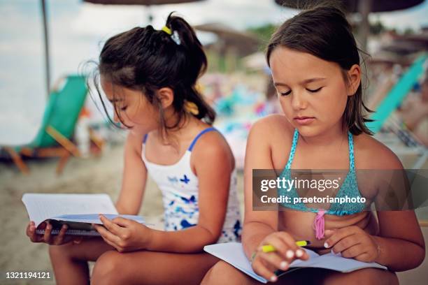 fidanzate infelici stanno imparando sulla spiaggia - study at home foto e immagini stock