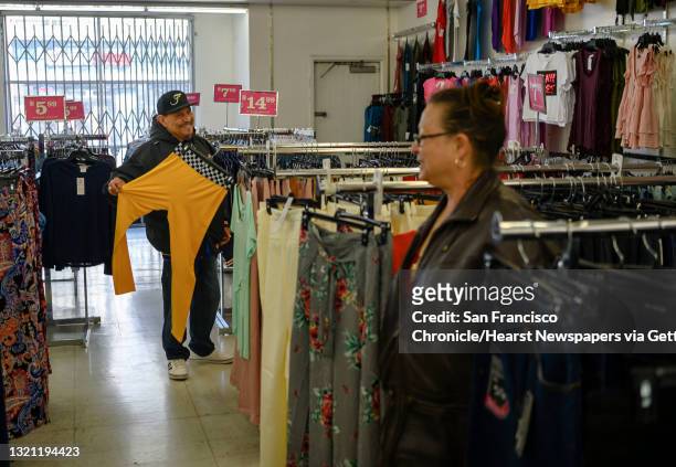 JosÈ Najera playfully shows a pair of bright yellow leggings to his wife Doris Ruiz to try and convince her to purchase them as they hop in the...