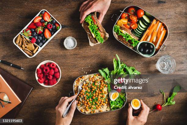 people having balanced diet from lunch boxes - groenten en fruitafdeling stockfoto's en -beelden