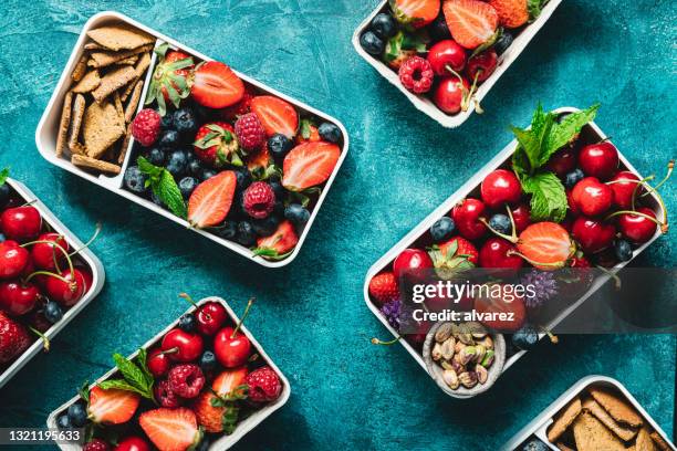 fruits lunch boxes on blue background - bento box above stock pictures, royalty-free photos & images