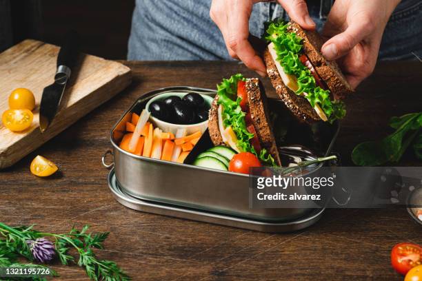 closeup of a woman preparing a healthy lunch box - making a sandwich stockfoto's en -beelden