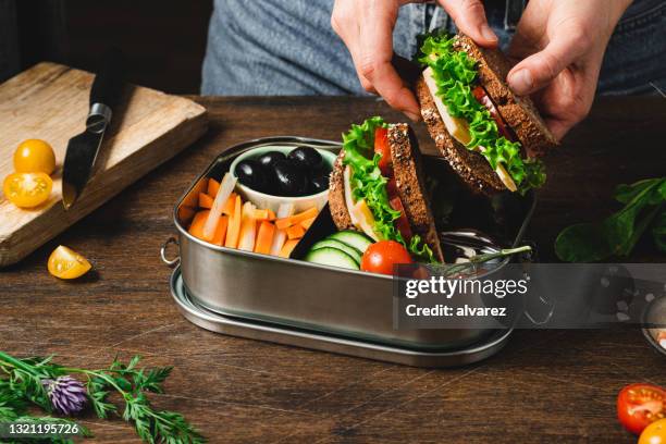 closeup of a woman preparing a healthy lunch box - lunch bag stock pictures, royalty-free photos & images