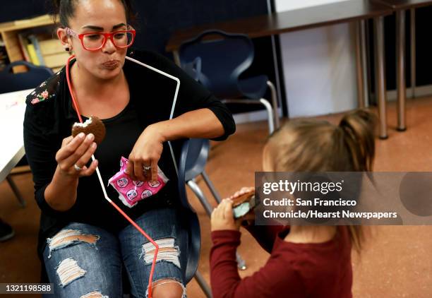 Elizabeth Lima watches her daughter, Robyn Lima eat an ice cream sandwich during drawing class at the Hamilton Family Shelter, located at 260 Golden...