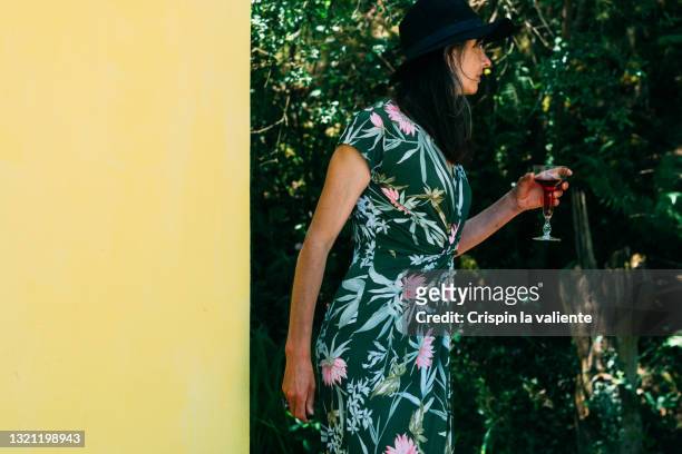 elegant middle-aged woman with a glass of wine outdoors - wohltätigkeitsfest stock-fotos und bilder